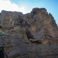 北の鼻の浜へと続く道の横にそそり立つ岸壁の写真