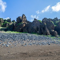 北の鼻の断崖とその足元に広がる石積の写真