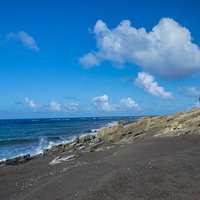 海に向かって傾斜する北の鼻の海岸の岩場の写真
