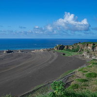 ▲度重なる隆起でできた砂浜の年輪にような海岸線の跡の写真