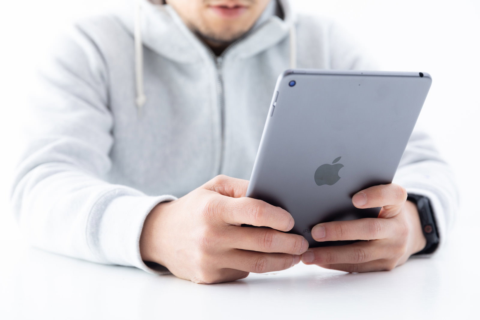 両手でiPad miniを持つ男性［モデル：g.O.R.i］