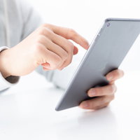 iPadminiを片手持ちしてスワイプする一本指操作の写真