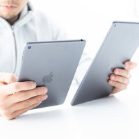 iPadのディスプレイを細かく見比べる男性の写真