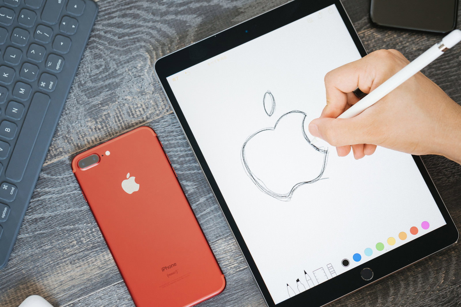 iPadにApple Pencilでアップルのロゴをスケッチする絵師の手元