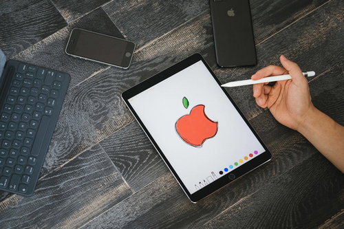 iPadのタブレットでAppleマークを描く絵師の手元