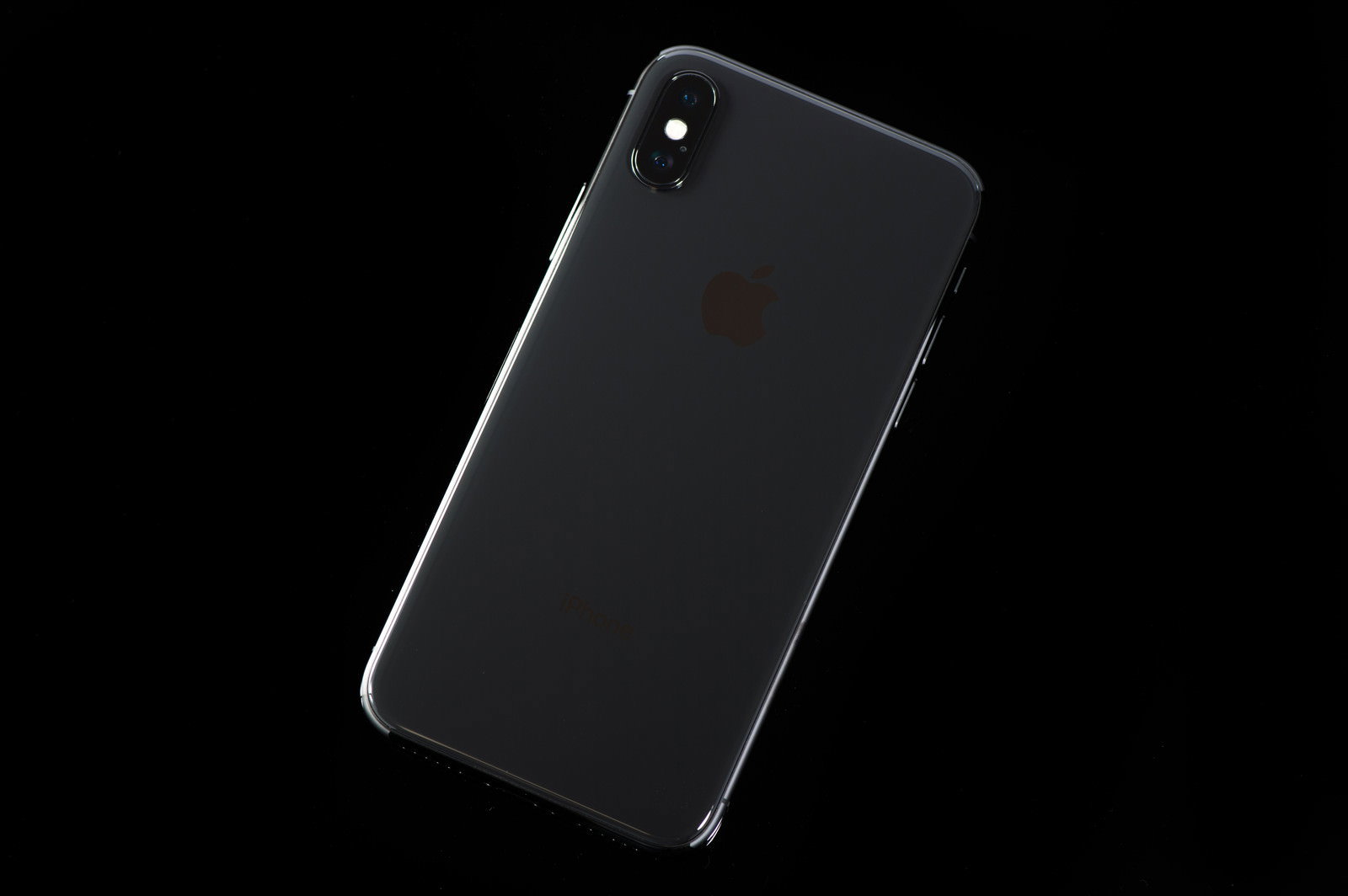 黒い背景に置かれたiPhone Xの背面デザイン