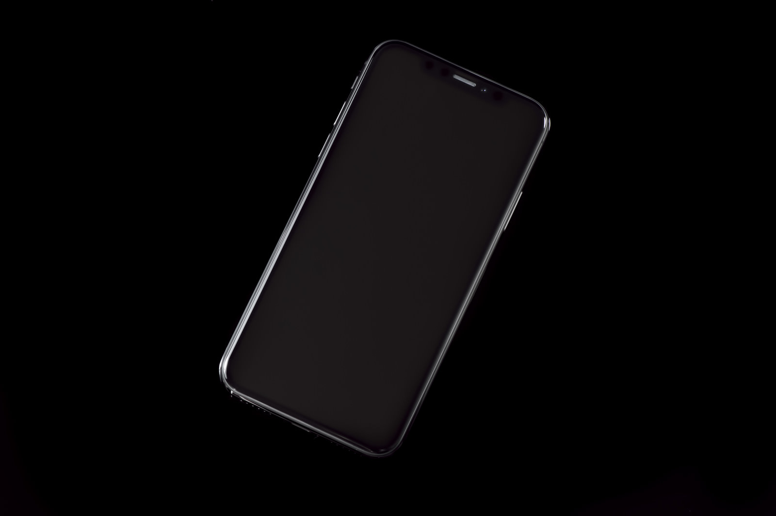 黒い背景に斜めに置かれたiPhone X スペースグレイ（画面オフ状態）