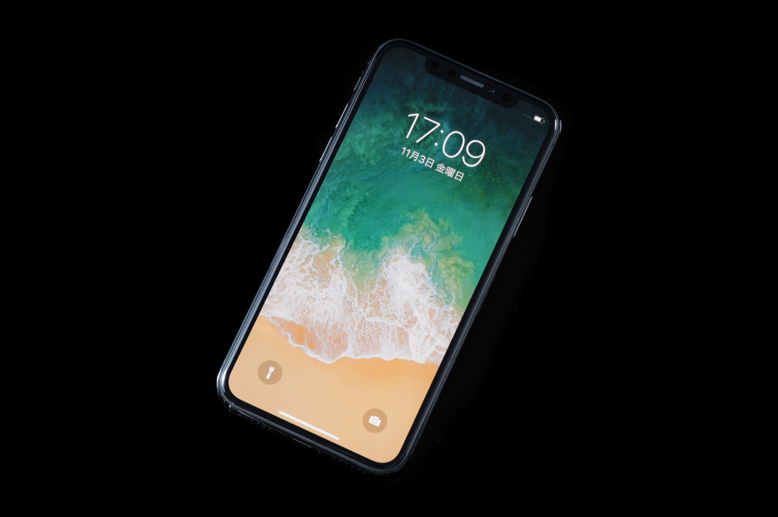 黒い背景に置かれたスペースグレイのiPhone X