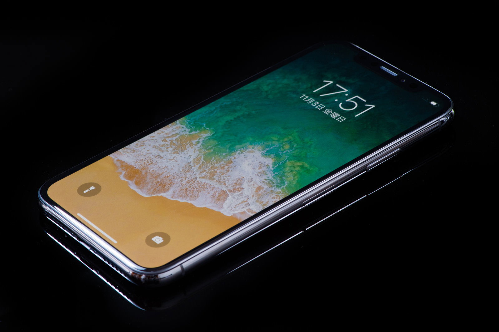 黒い背景に置かれたiPhone Xのステンレススチールフレーム