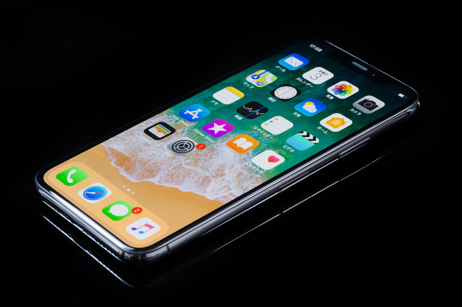 黒い背景に置かれたiPhone Xのホーム画面