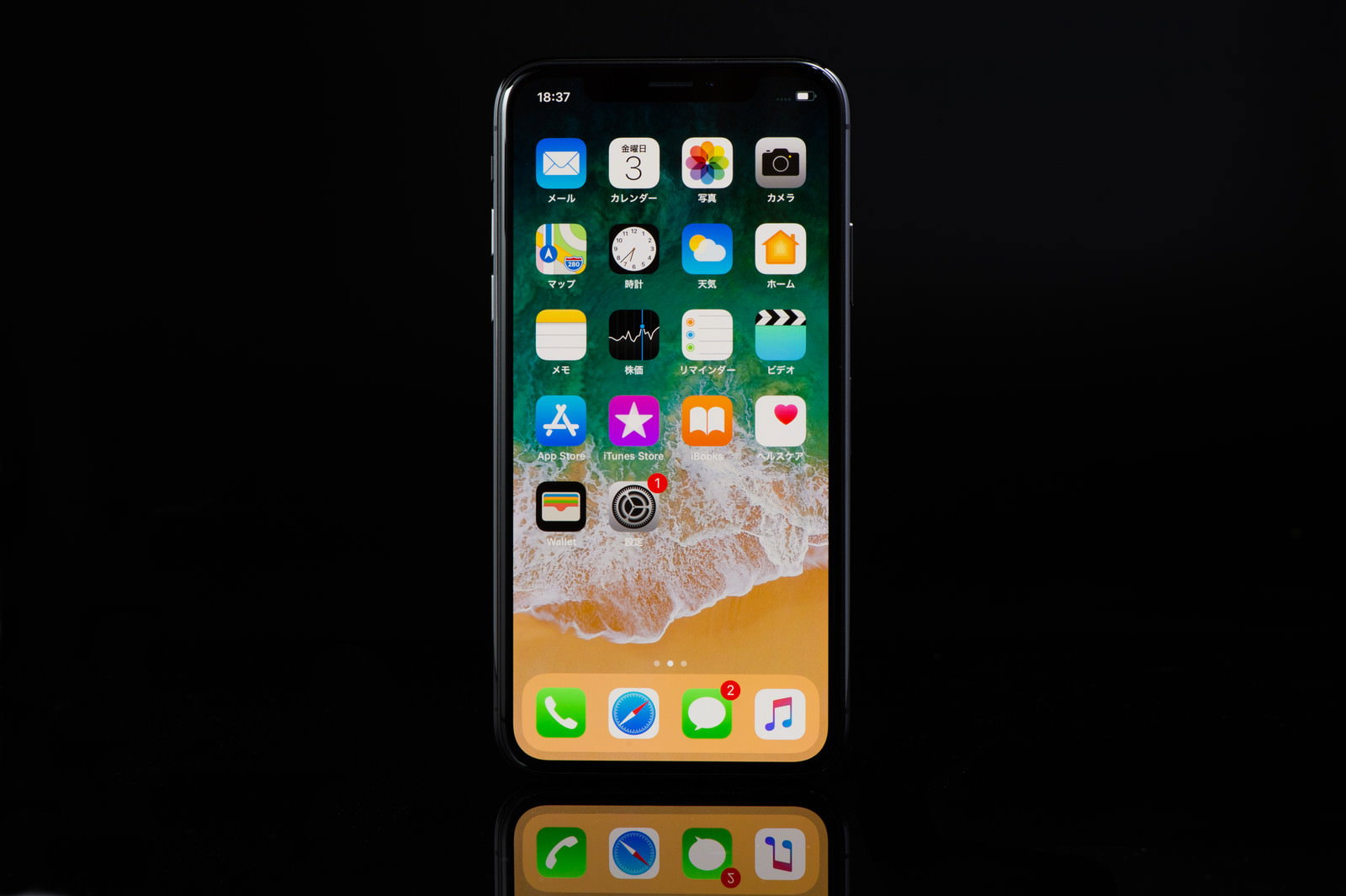 黒い背景に置かれたスペースグレイのiPhone Xのホーム画面