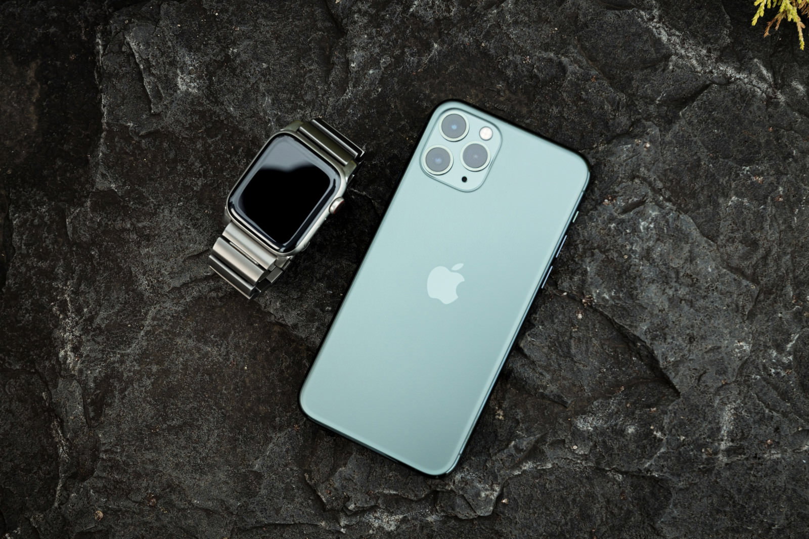 黒い大理石調の背景にiPhone 11 Pro ミッドナイトグリーンとApple Watchが並んで置かれている