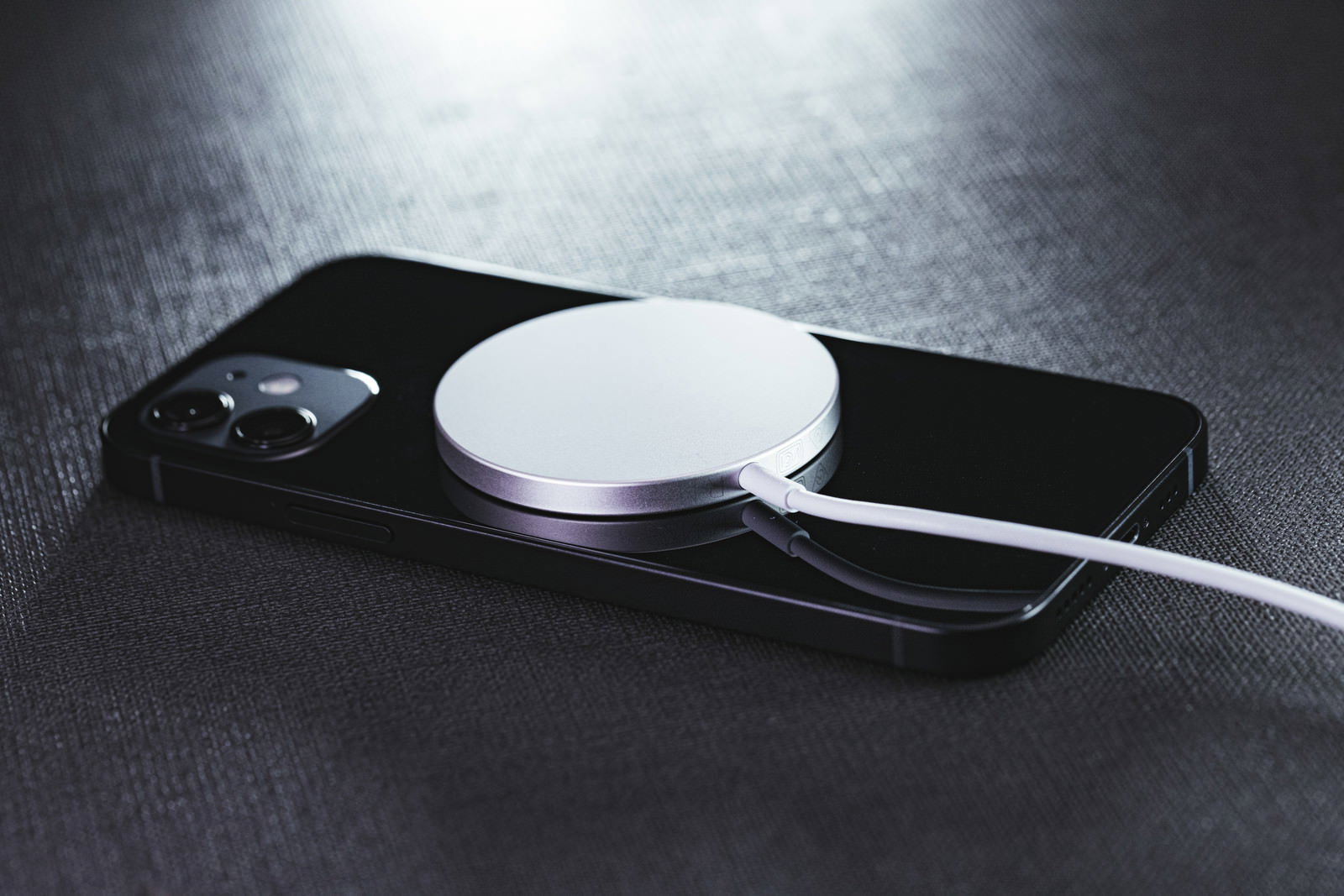 黒いiPhone12がMagSafe充電器で充電されている様子