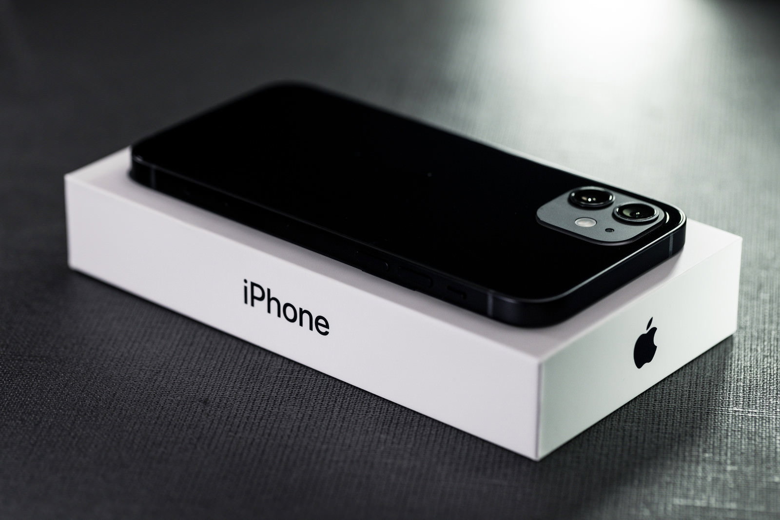 白い箱の上に置かれた黒いiPhone12のクローズアップ