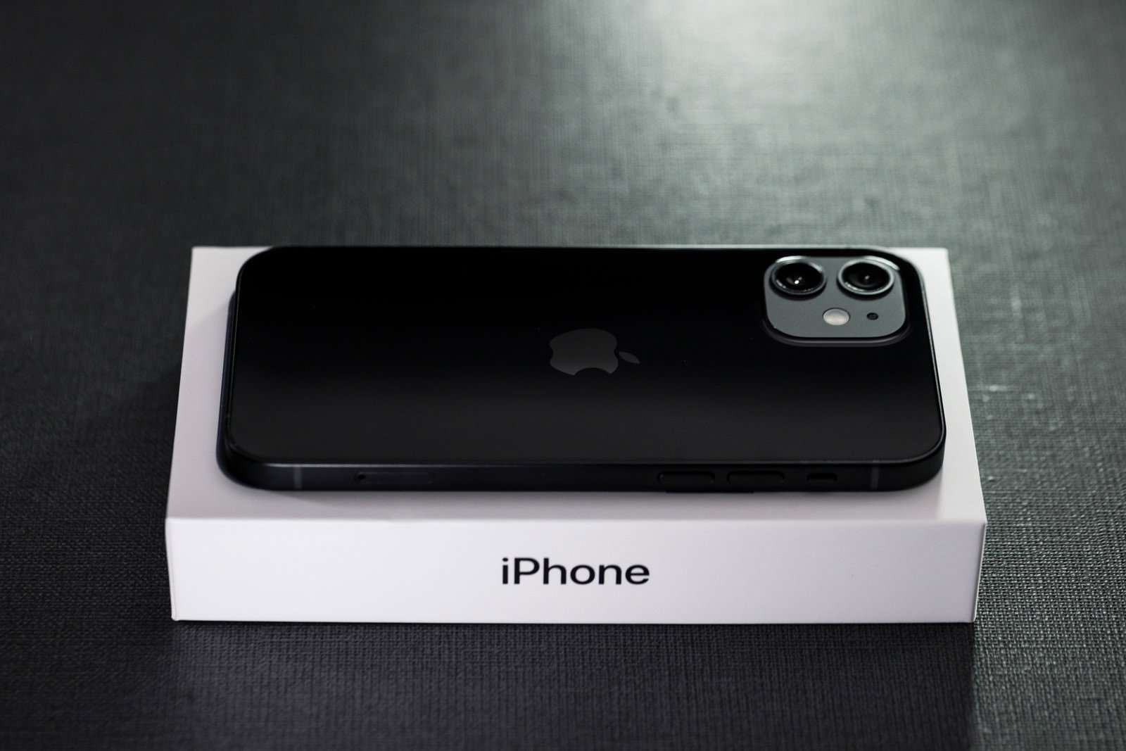 白い箱の上に置かれた黒いiPhone12のスマートフォン