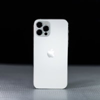 黒い背景に立てかけられた白いiPhone12の影の写真