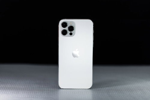 黒い背景に立てかけられた白いiPhone12の影