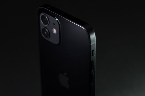 暗闇から浮かび上がるiPhone12（ブラック）のサイドボタン