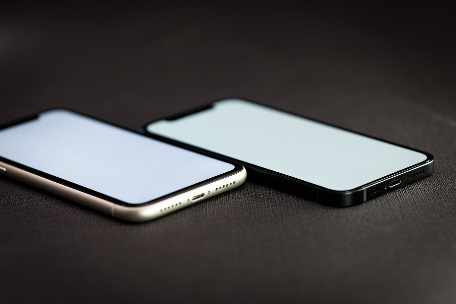 黒い背景にiPhone 11とiPhone 12が並べて置かれている