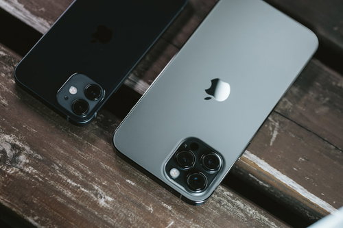 木目のテーブルに並ぶiPhone 12とiPhone 12 Pro