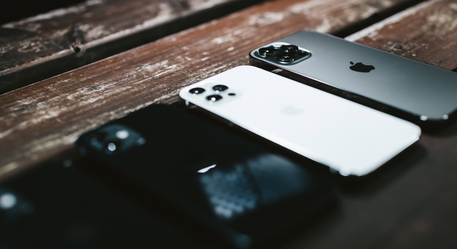木製のテーブルに置かれたiPhone 12 Pro Maxのリアカメラ部分