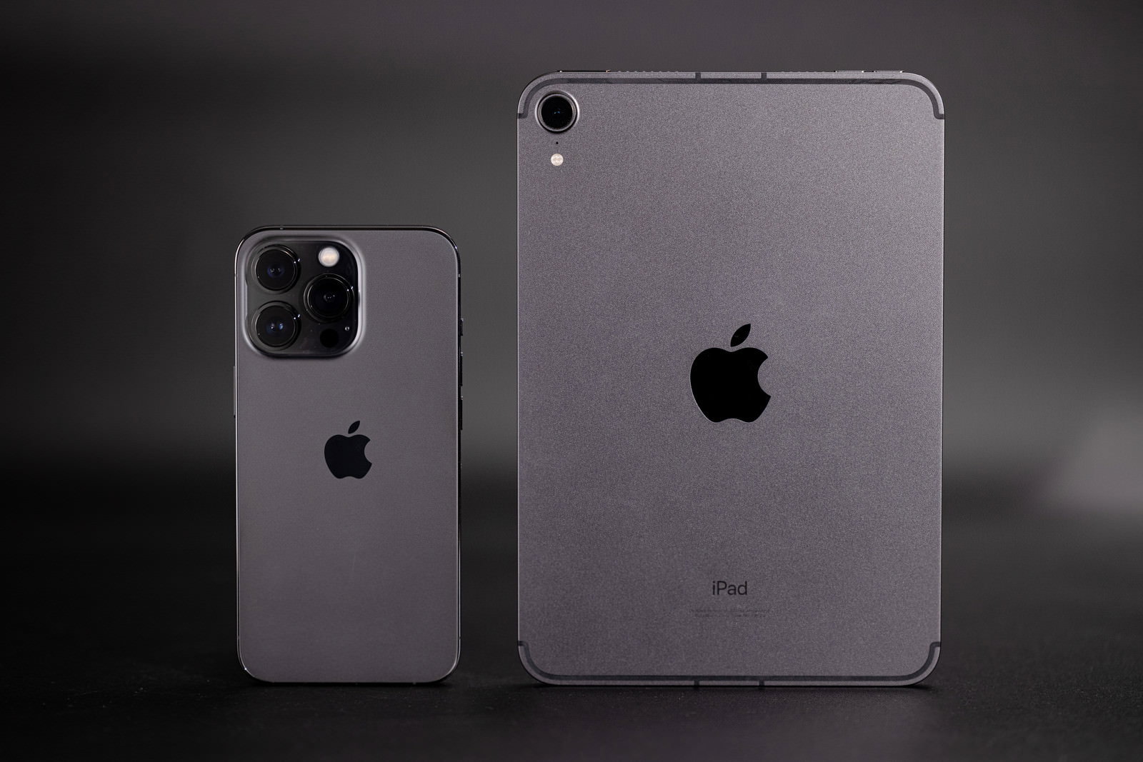 グレーの背景に並んで置かれたiPhone 13 ProとiPad mini