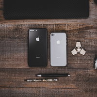 木目調のテーブルに置かれたiPhoneなどの写真