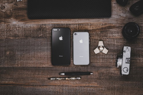 木目調のテーブルに置かれたiPhoneなど