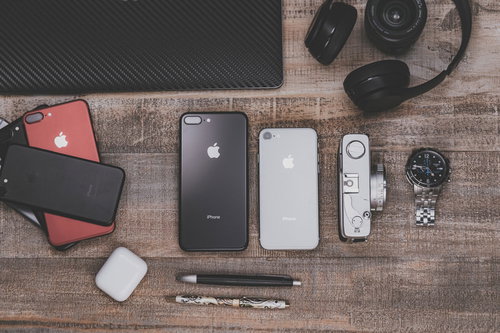 木目のテーブルに置かれたガジェットと最新スマホ