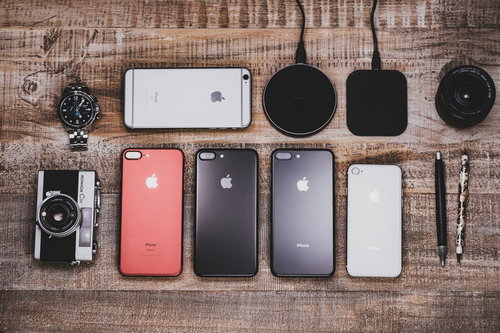 テーブルに置かれたガジェット系ブロガーの所有物、iPhoneやカメラなど