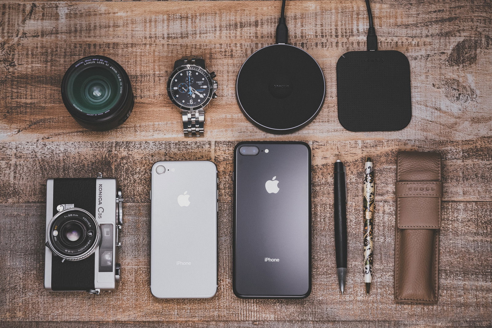 テーブルにiPhoneやワイヤレス充電器などガジェットを平置きした俯瞰写真