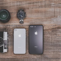 木目調のテーブルに並べたiPhone8とガジェットアイテムの写真