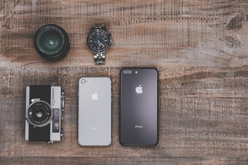 木目調のテーブルに並べたiPhone8とガジェットアイテム