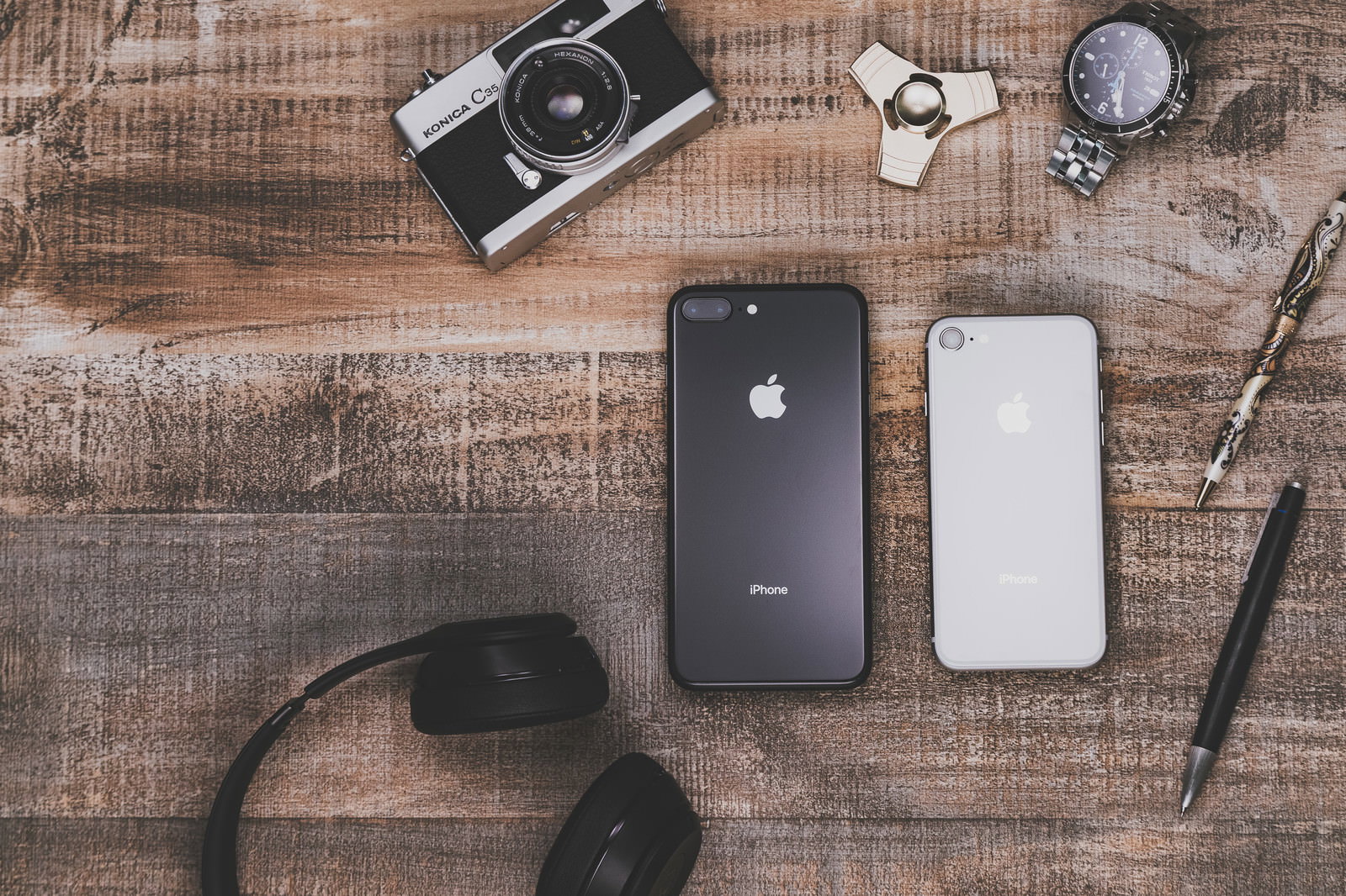 テーブルの上にiPhoneやカメラなどの小物が並ぶ