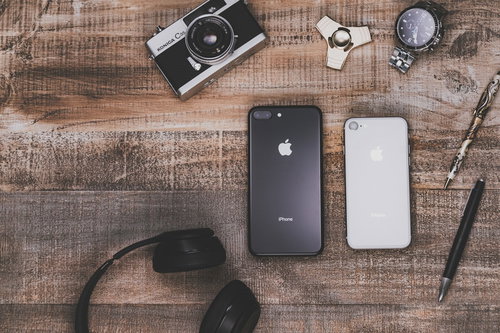 テーブルの上に散らばったiPhoneや小物