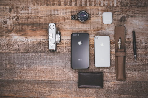 木目のテーブルに置かれたiPhoneや小物