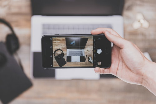 テーブルに置かれたノートPCをiPhoneで撮影