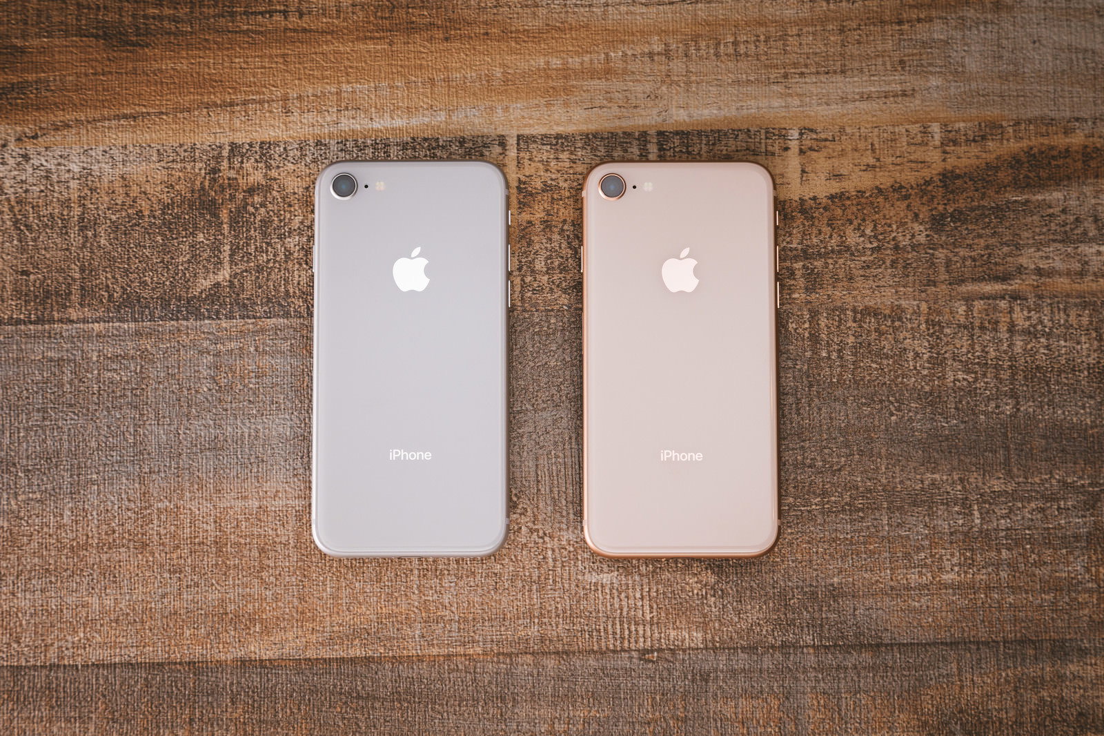 テーブルに並ぶシルバーとゴールドのiPhone 8背面