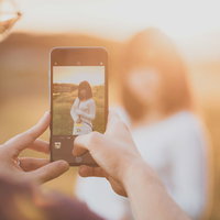 逆光の中iPhoneでグラドルを撮影中のブロガーの写真