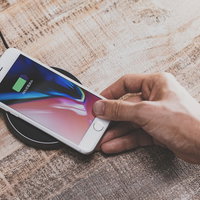 無線充電パッドにiPhoneをかざして充電する様子の写真