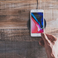iPhone 8 をワイヤレス充電パッドにかざすの写真