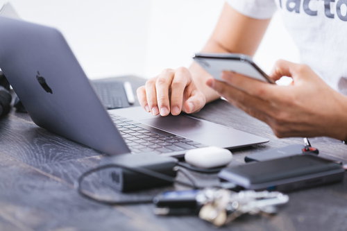 スマホで修正依頼を確認しながらコーディングするエンジニア