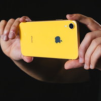 黄色いiPhoneXRの外向きカメラで撮影する手元の写真