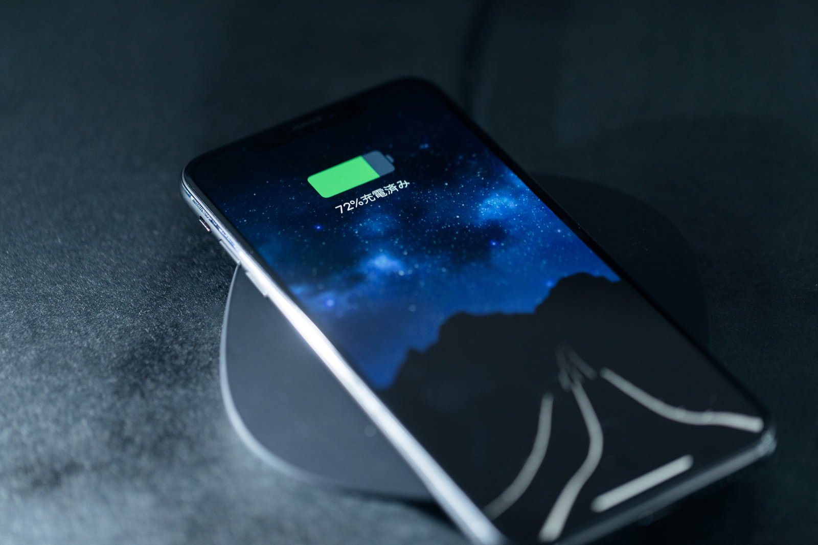 充電パッド上で無線充電中のiPhone、画面に充電状況表示