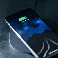 ワイヤレス充電パッド上で無線充電中のiPhone XSの写真