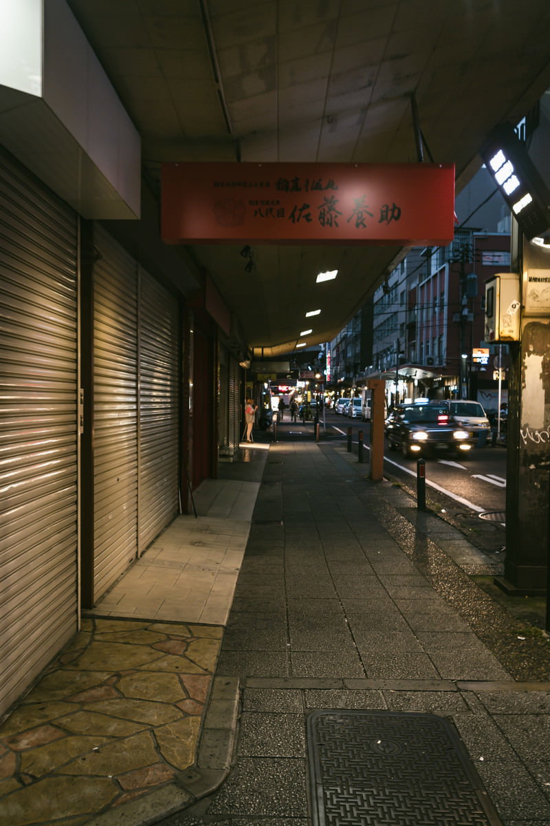 夜の福富町国際通り商店街のアーケード、石畳の歩道とシャッター街