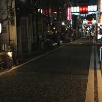路地から見る野毛小路の赤と青の電飾看板と居酒屋街の夜景の写真