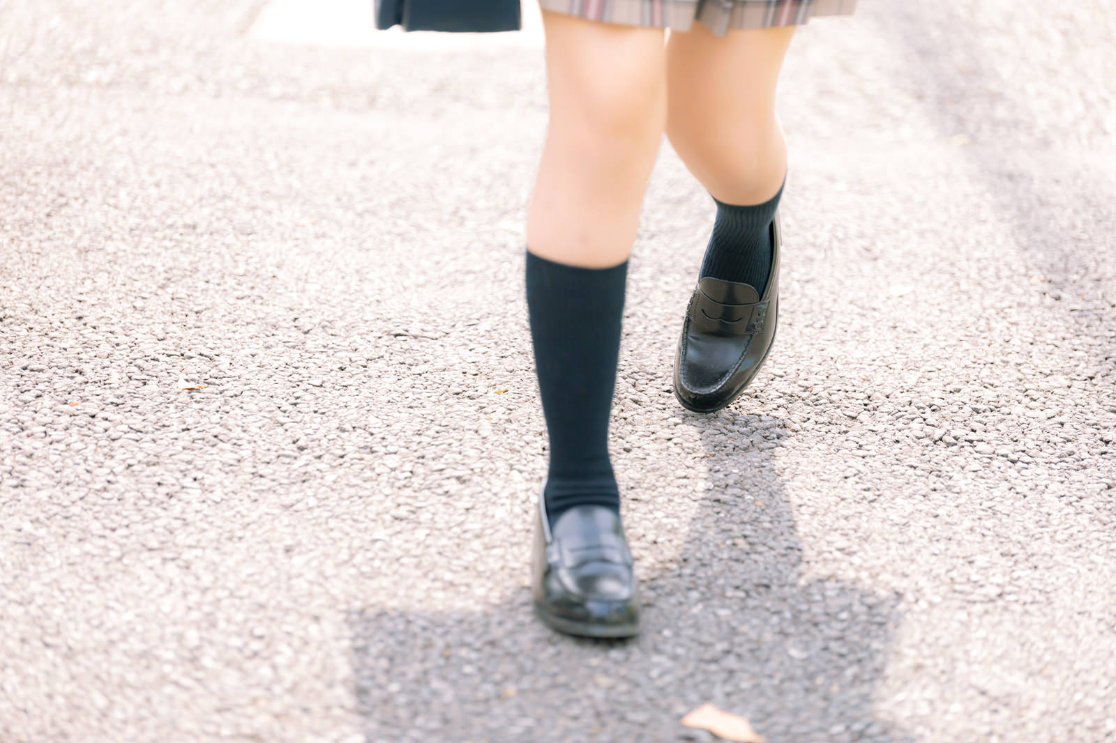 紺色のハイソックスに黒いローファーを履いて通学する女子高生の足元［モデル：石投げて美奈代］