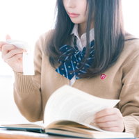 制服姿で単語カードを使って暗記学習中の女子高生の写真