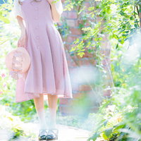 春の木漏れ日に包まれて散歩する女性の写真
